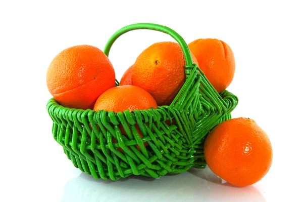 Апельсини в зеленому кошику — стокове фото