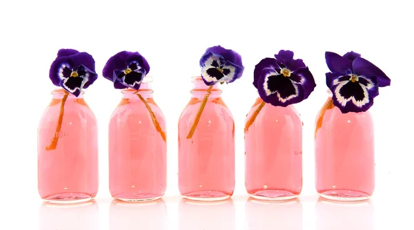 Fila con Pansies en pequeñas botellas —  Fotos de Stock