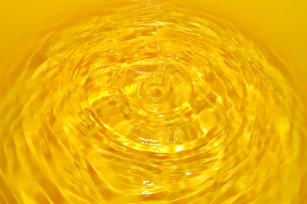 Smält guld i kopp vatten — Stockfoto