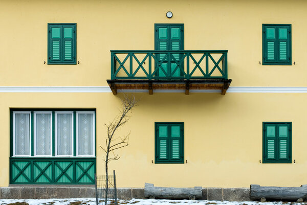 The front of a house in Northern Italy, complete with windows, shutters, and a balcony.