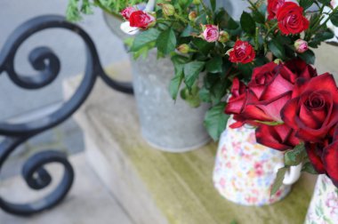 Buckets with red roses on an staircase