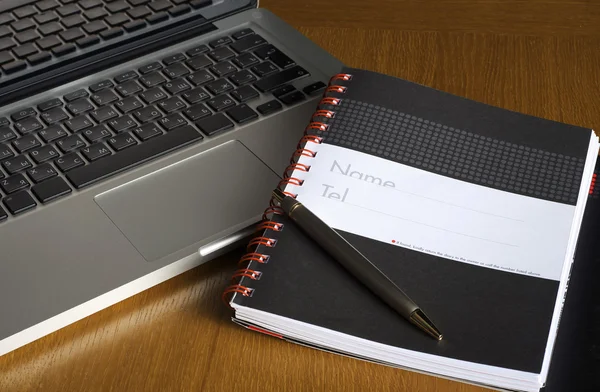 Telefonu, laptopa i pusty notebook na biurku — Zdjęcie stockowe