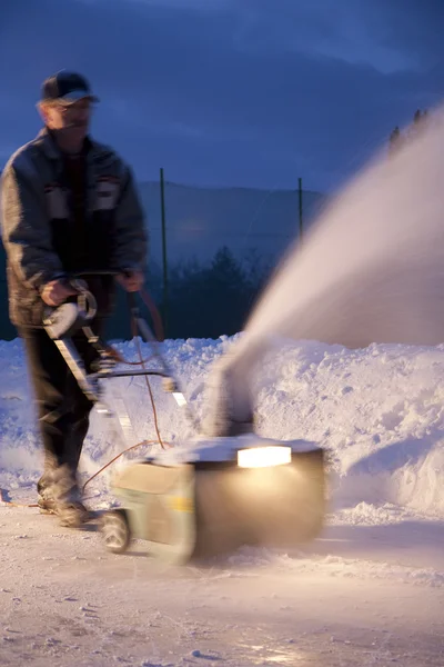 Человек, работающий со снегоочистителем — стоковое фото