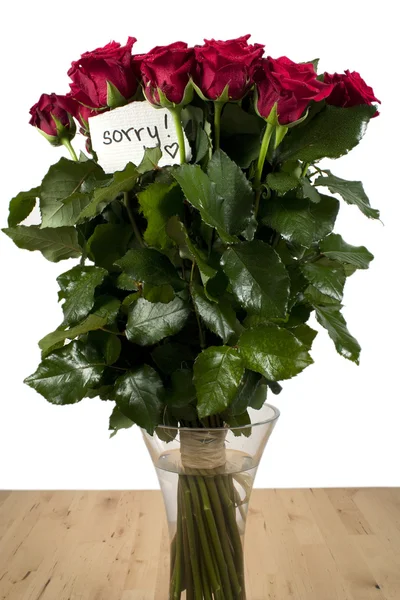 Un bouquet de roses dans un vase en verre avec note — Photo