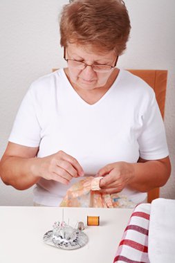 Elderly woman sewing clipart