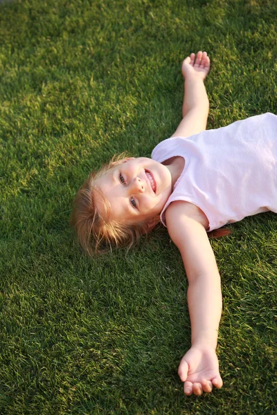 Menina feliz relaxando em uma grama — Fotografia de Stock