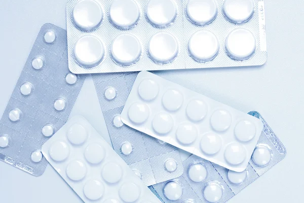 Tabletták, háttérben a kék hangot — Stock Fotó