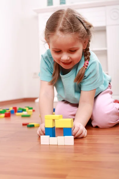 Очаровательная девушка играет с блоками — стоковое фото