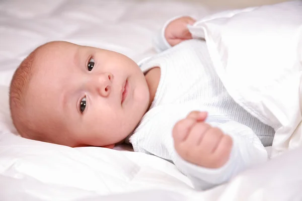 Очаровательный новорожденный в постели — стоковое фото