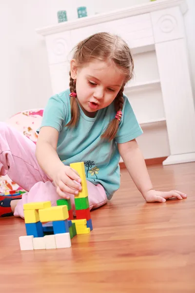 Очаровательная девушка играет с блоками — стоковое фото