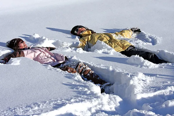 Madre e figlia sdraiata nella neve Fotografia Stock