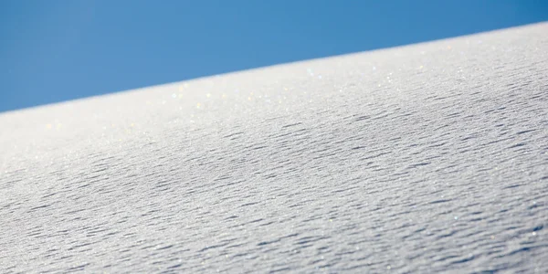 Čerstvé sněhové vločky a modrá obloha — Stock fotografie