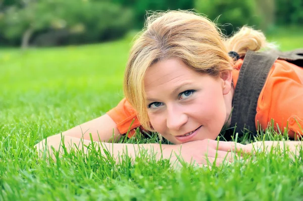 Jovem mulher relaxante na grama — Fotografia de Stock