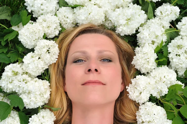 Young woman laying in flowers — Stock Photo, Image