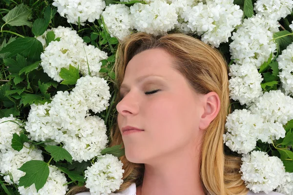 年轻女子躺在鲜花 — 图库照片