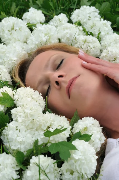 Молода жінка, що лежить у квітах — стокове фото