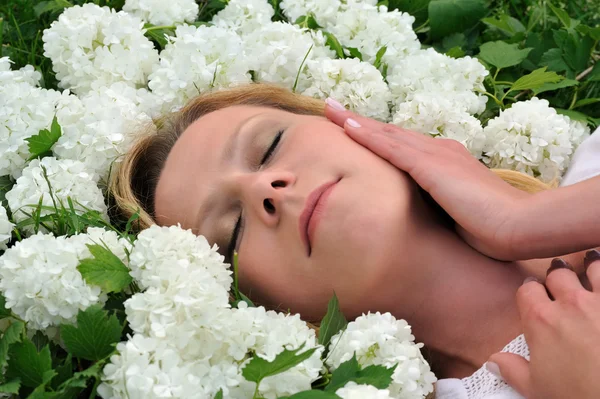 年轻女子躺在鲜花 — 图库照片