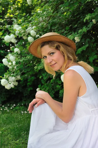 Bahçede oturan genç bir kadın — Stok fotoğraf