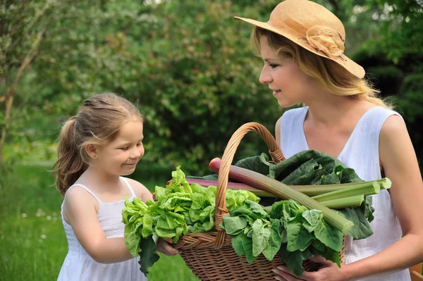 Mladá žena a dcera se zeleninou — Stock fotografie