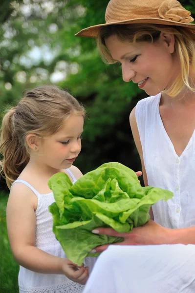 Young mother and daughter with lettuce — Stock Photo, Image