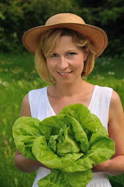 Junge Frau hält frischen Salat in der Hand — Stockfoto