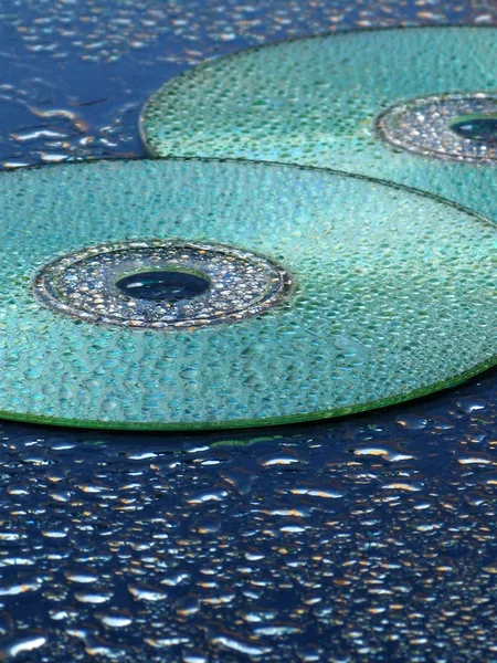 CD e água cai sobre fundo azul — Fotografia de Stock