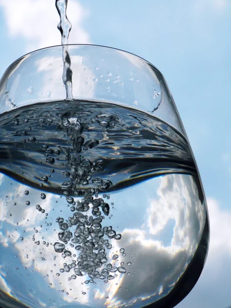 Glass of pouring water with reflection — Stock Photo, Image