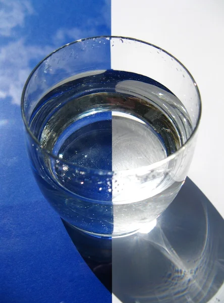 Vidro de água sobre fundo azul — Fotografia de Stock