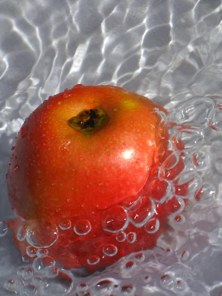 Apple in water with air bubbles — Stock Photo, Image