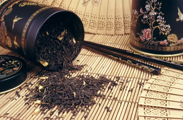 Black tea spilling out - still life — Stock Photo, Image