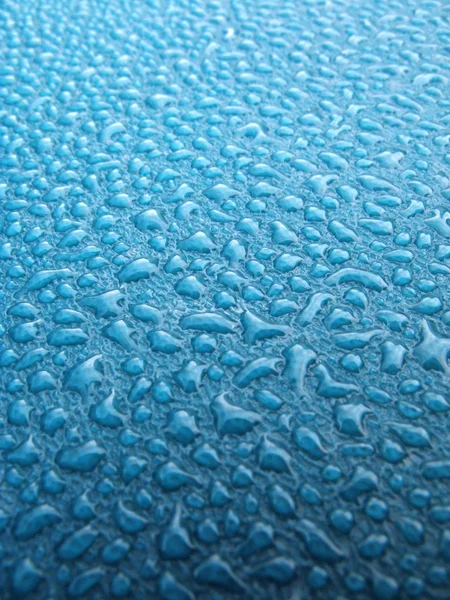 Kapky vody nad modrý plastový materiál — Stock fotografie