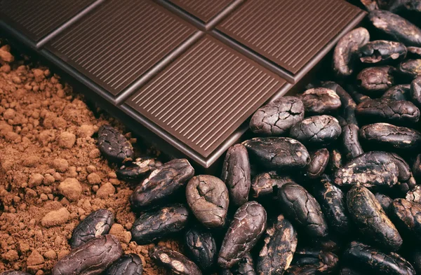 Staaf-van-chocolade, stukjes cacaobonen, poeder Stockfoto