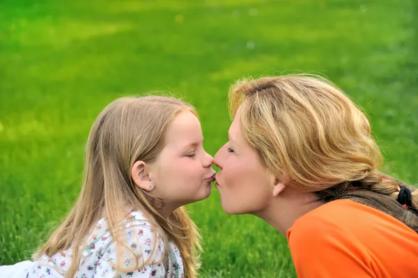 Mãe está beijando sua filha — Fotografia de Stock