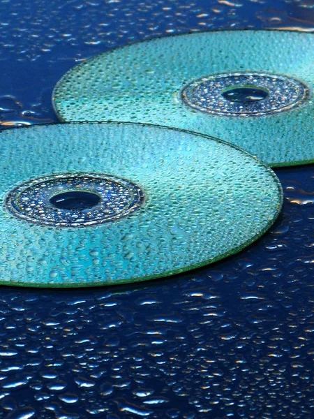 CD et gouttes d'eau sur fond bleu — Photo