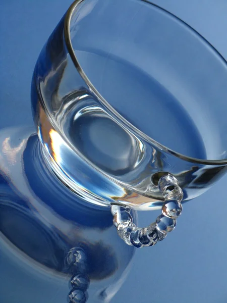 Glas en water over blauwe achtergrond — Stockfoto