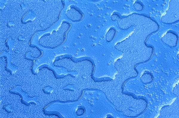 Gotas de água sobre material plástico azul — Fotografia de Stock