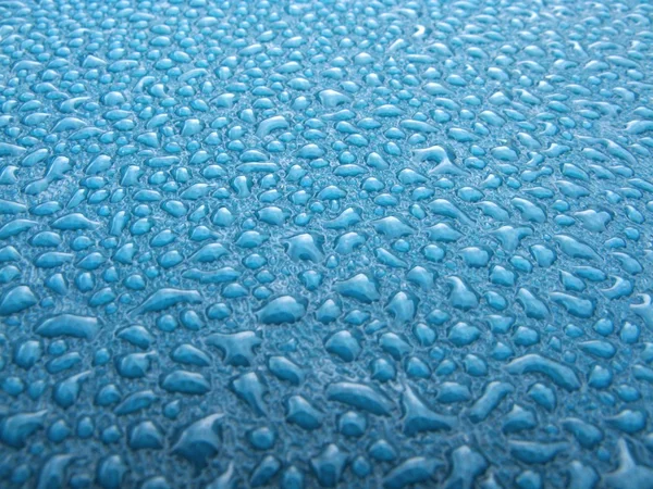 Капли воды на синий пластик — стоковое фото