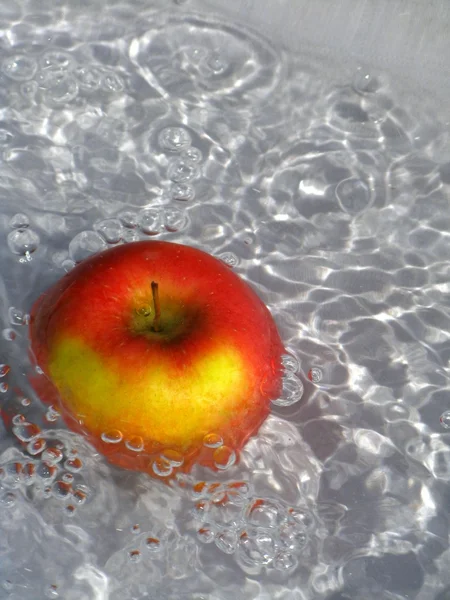 Jabłko w wodzie z pęcherzyków powietrza — Zdjęcie stockowe
