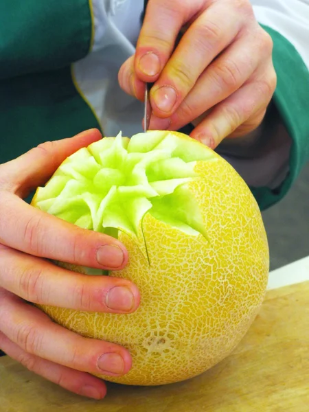 Cantalupe meloen en handen - carving — Stockfoto