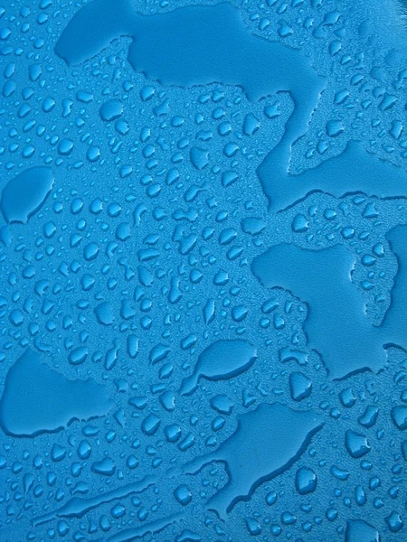 Gocce d'acqua sopra materiale plastico blu — Foto Stock
