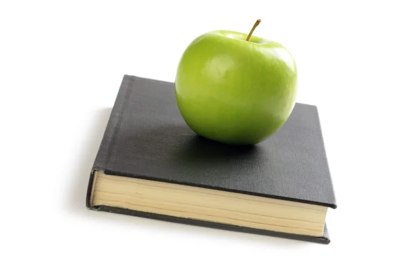 Зеленое яблоко на книге — стоковое фото