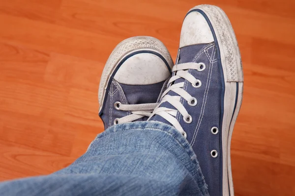 Человеческая нога в джинсах и кроссовках — стоковое фото