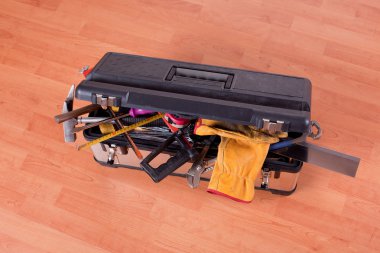 Tools in tool box on wooden floor clipart