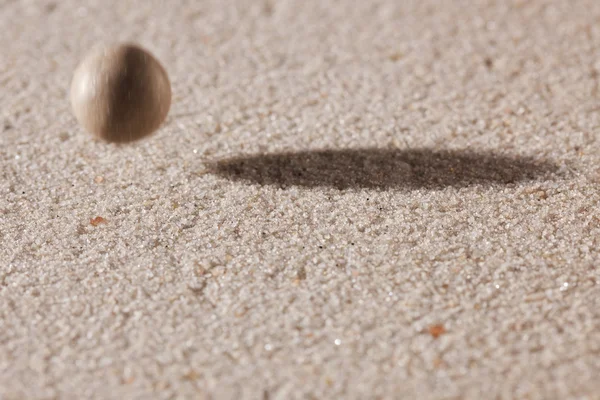 Stone falling down in sand — Stock Photo, Image