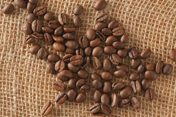 Granos de café sobre yute — Foto de Stock