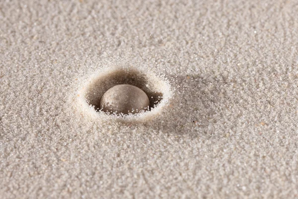 Pierre tombant dans le sable — Photo