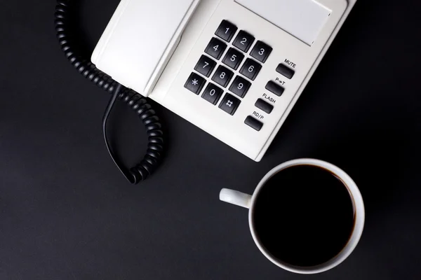 Kaffeetasse und weißes Telefon — Stockfoto