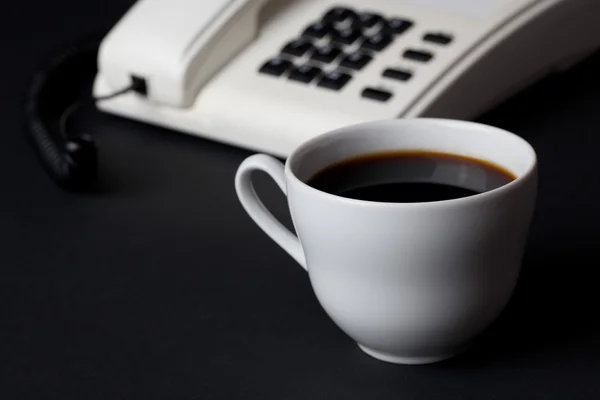 コーヒーのカップと白の電話 — ストック写真