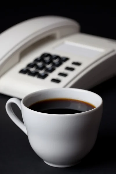 Coffee cup and white telephone — Stock Photo, Image