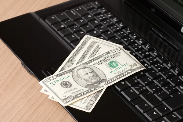 Billets en dollars sur clavier d'ordinateur portable — Photo